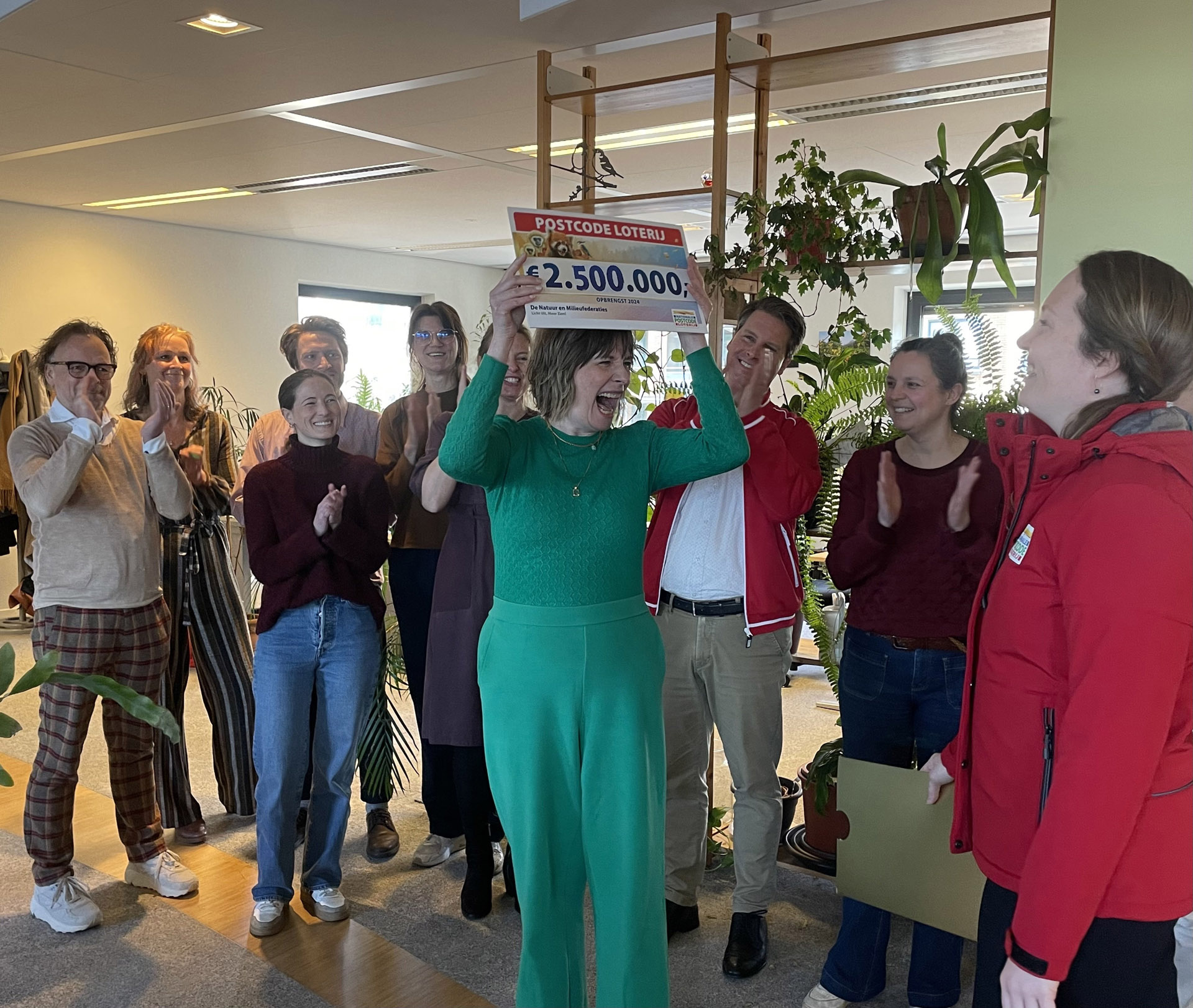 Een blij moment bij de Natuur en Milieufederaties op kantoor toen de cheque van de Postcode Loterij werd overhandigd